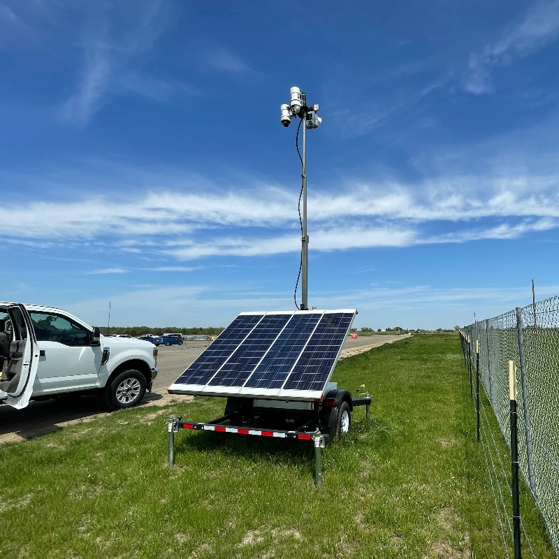 A Solar Surveillance Trailer by Chain Link Fence